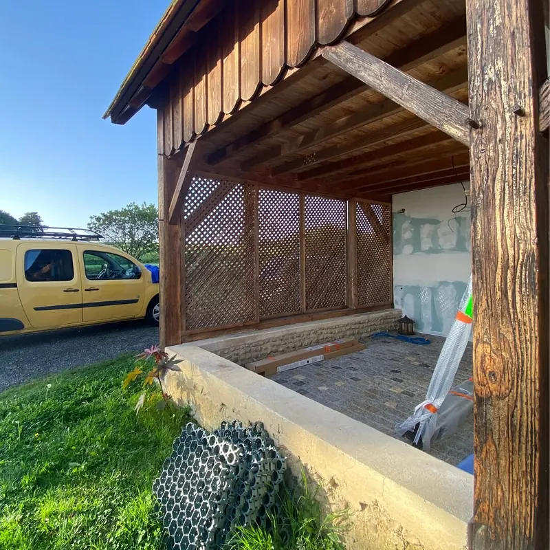 Dépendance vue de l’extérieur pendant les travaux : charpente en bois, treillis encore en place, murs intérieurs en plaques de plâtre